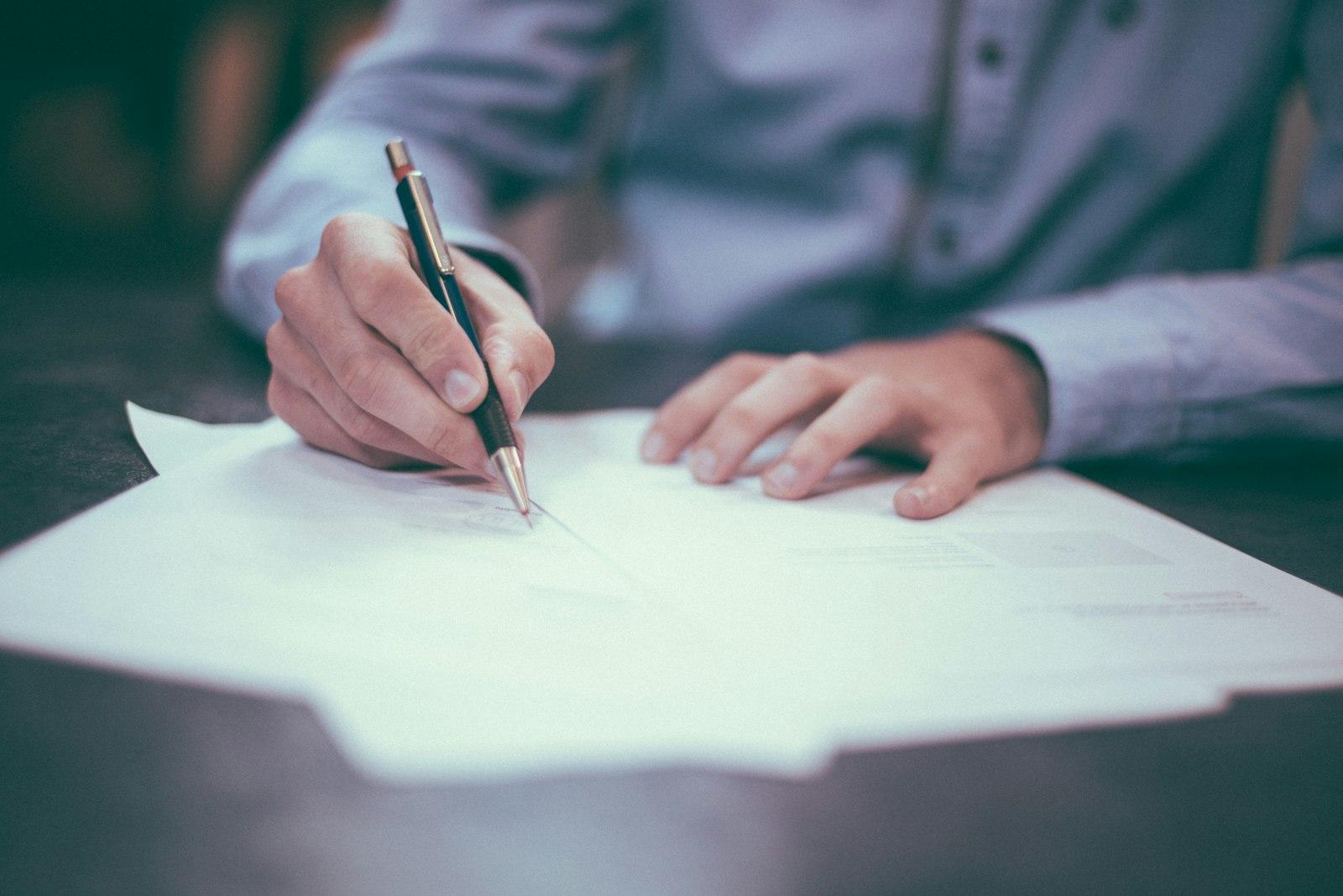 Signing accounting paperwork with a pen